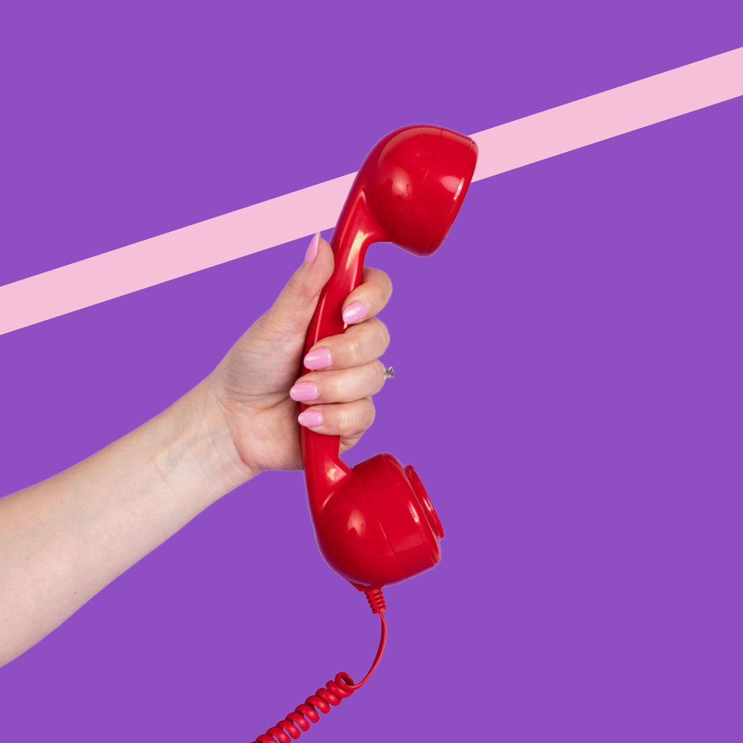 Hand holding red phone on purple background