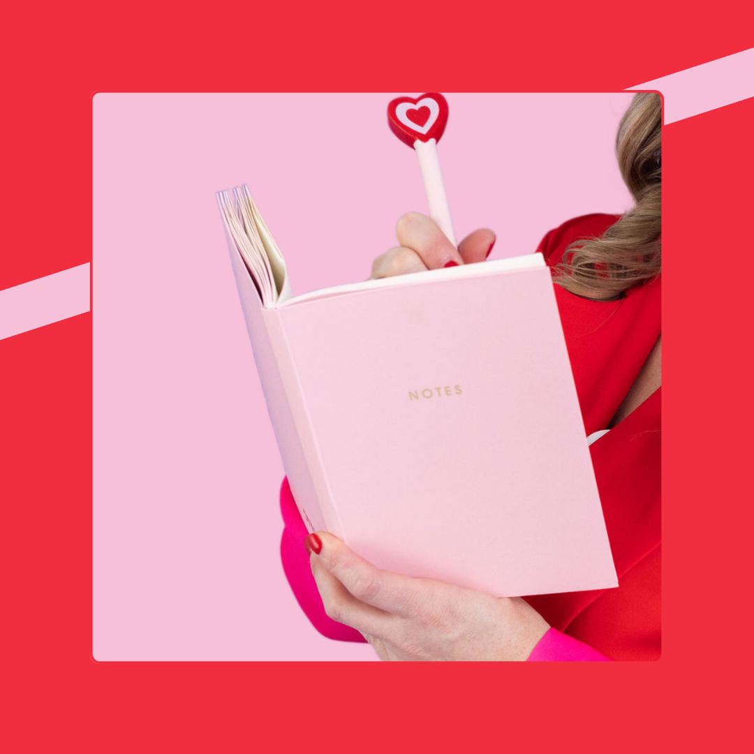 Woman holding a pink notebook and pen